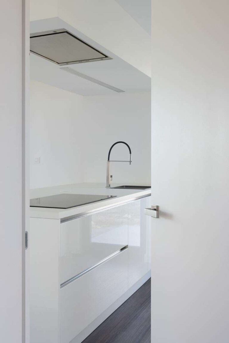 Moderne open witte deur met uitzicht op een keukenkraan