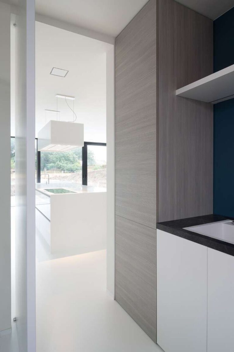 Open moderne witte deur met uitzicht op een keuken
