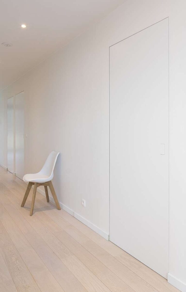 onzichtbare, moderne witte binnendeur met een witte stoel