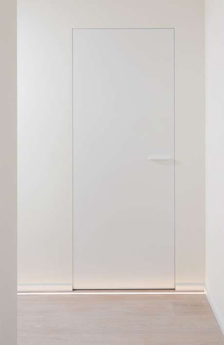 Gesloten moderne witte deur met een witte deurklink