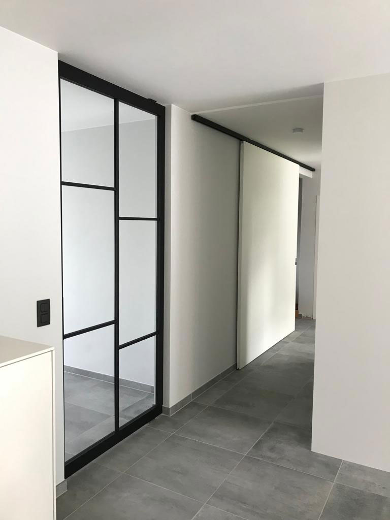 Zwarte steel look aluminium deur met glas in een moderne setting